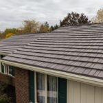 House with brown shingle roof and brick walls.