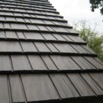 Close-up of a shingle rooftop under cloudy sky.